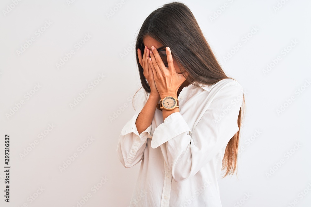 Young beautiful businesswoman wearing glasses standing over isolated white background with sad expression covering face with hands while crying. Depression concept. Young beautiful businesswoman wearing glasses standing over isolated white background with sad expression covering face with hands while crying. Depression concept.
