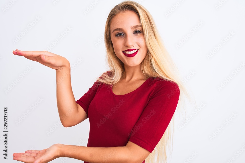 Young beautiful woman wearing red t-shirt standing over isolated white background gesturing with hands showing big and large size sign, measure symbol. Smiling looking at the camera Young beautiful woman wearing red t-shirt standing over isolated white background gesturing with hands showing big and large size sign, measure symbol. Smiling looking at the camera