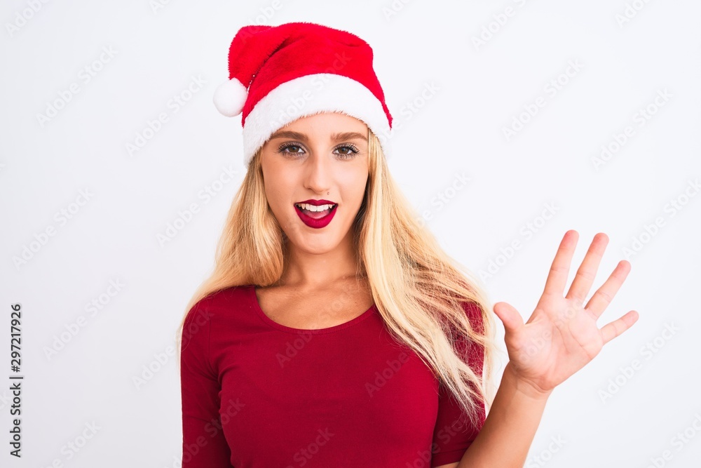 Young beautiful woman wearing Christmas Santa hat over isolated white background showing and pointing up with fingers number five while smiling confident and happy. Young beautiful woman wearing Christmas Santa hat over isolated white background showing and pointing up with fingers number five while smiling confident and happy.