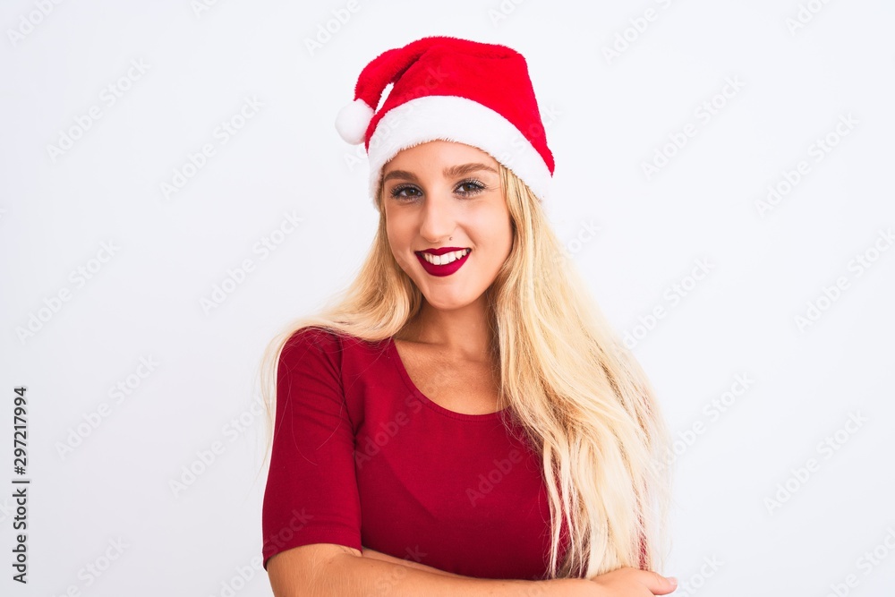 Young beautiful woman wearing Christmas Santa hat over isolated white background happy face smiling with crossed arms looking at the camera. Positive person. Young beautiful woman wearing Christmas Santa hat over isolated white background happy face smiling with crossed arms looking at the camera. Positive person.