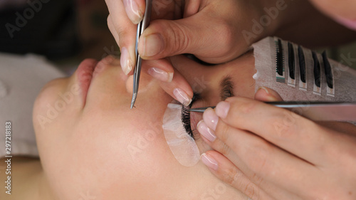 Beautiful Woman with long eyelashes in a beauty salon. Eyelash extension procedure.