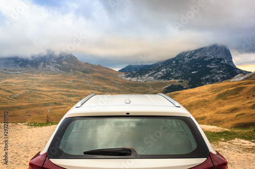 Autumn mountain landscape. View from behind a white car. Durmitor National Park, Montenegro. Focus on the car