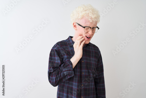 Young albino blond man wearing casual shirt and glasses over isolated white background touching mouth with hand with painful expression because of toothache or dental illness on teeth. Dentist