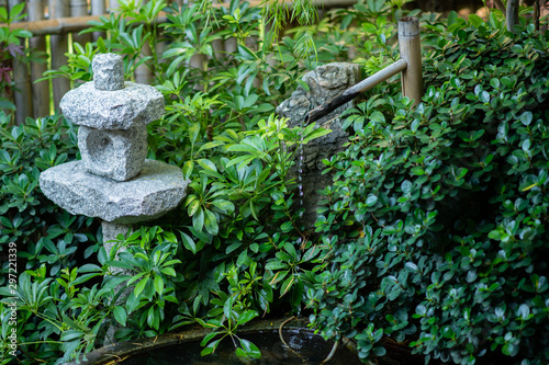 Japanese style garden With water flowing out of the bamboo into a small basin