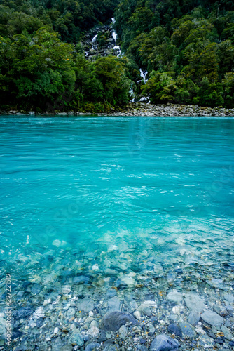New Zealand tourism glacial blue river with waterfall © Steve Munro