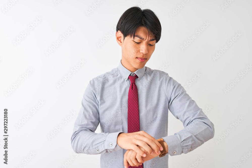 Chinese businessman wearing elegant tie standing over isolated white background Checking the time on wrist watch, relaxed and confident