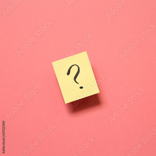 Question mark on memo paper on pink background. Solution concept