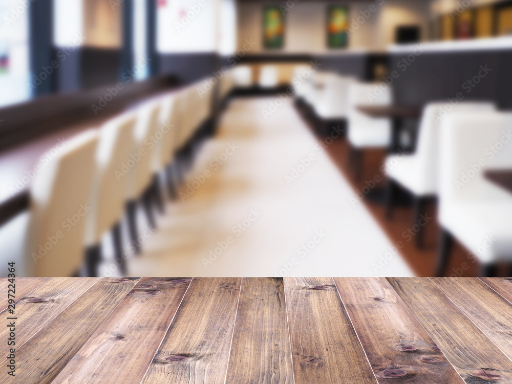 Wood table top over abstract blur background of cafe or restaurant interior. Wood table top over abstract blur background of cafe or restaurant interior.