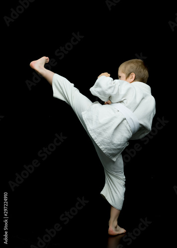 A little boy in a white kimono fulfills blows