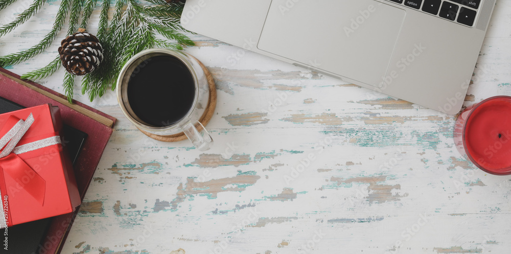 Top view of Christmas decorated workplace  with laptop computer, coffee cup and present on vintage wooden desk