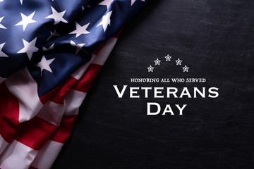 Happy Veterans Day. American flags with the text thank you veterans against a blackboard background. November 11.