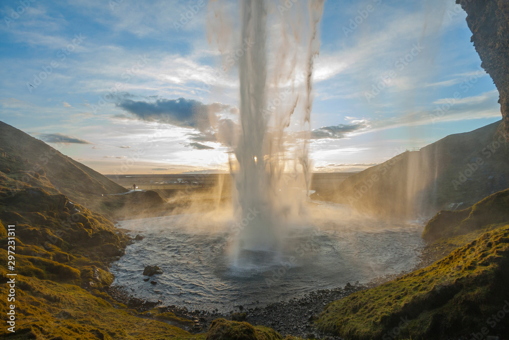 Waterfall Seljalandsfoss (part of Seljalands river taking its origin in Eyjafjallajökull volcano glacier) in southern Iceland, as seen in sunset hour Waterfall Seljalandsfoss (part of Seljalands river taking its origin in Eyjafjallajökull volcano glacier) in southern Iceland, as seen in sunset hour