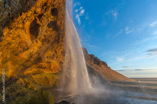 Wodospad Seljalandsfoss (część rzeki Seljalands, która bierze początek w lodowcu wulkanu Eyjafjallajökull) w południowej Islandii, jak widać w godzinie zachodu słońca
