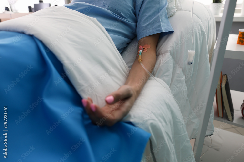 Hand of a young woman with a dropper in ward