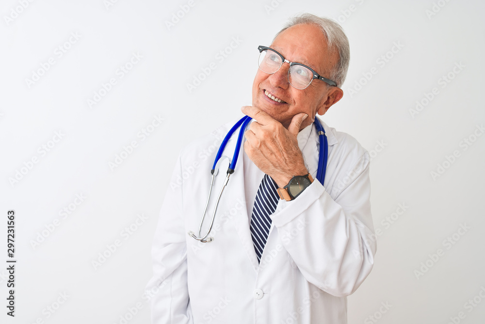 Senior grey-haired doctor man wearing stethoscope standing over isolated white background looking confident at the camera smiling with crossed arms and hand raised on chin. Thinking positive. Senior grey-haired doctor man wearing stethoscope standing over isolated white background looking confident at the camera smiling with crossed arms and hand raised on chin. Thinking positive.