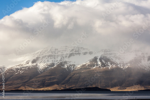 Icelandic fjords in Eastern part of island as pictured with snowstorm clouds and snow covered mountain ranges in the background © Andrew Sild