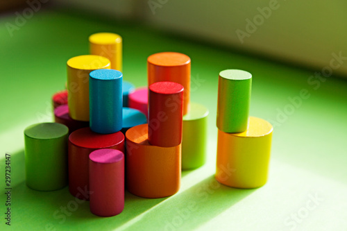 many different round small colored wooden sticks stacked on each other with green background
