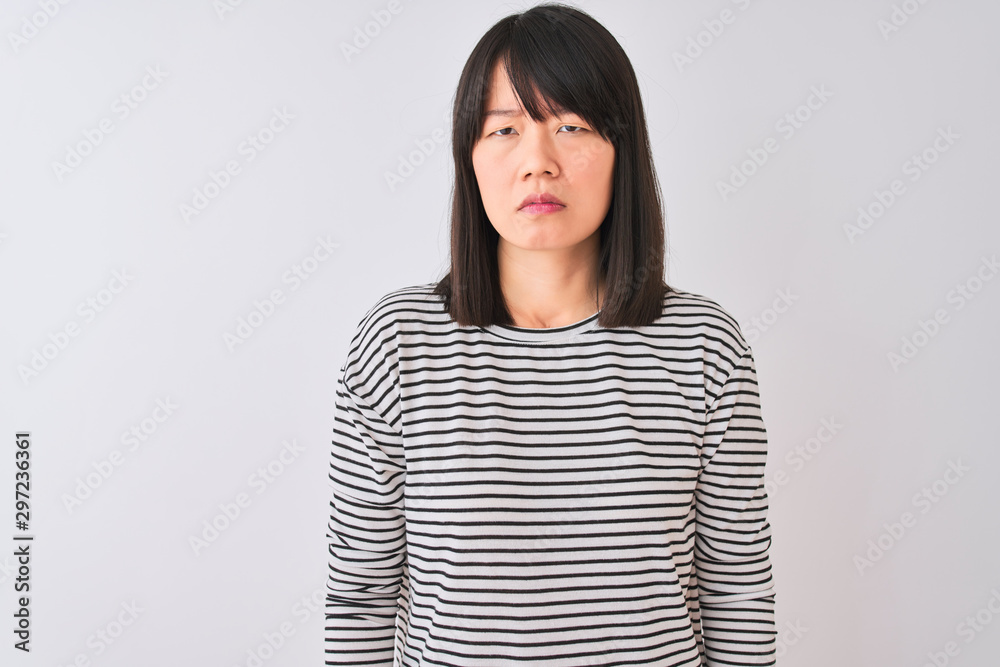 Young beautiful chinese woman wearing black striped t-shirt over isolated white background skeptic and nervous, frowning upset because of problem. Negative person. Young beautiful chinese woman wearing black striped t-shirt over isolated white background skeptic and nervous, frowning upset because of problem. Negative person.