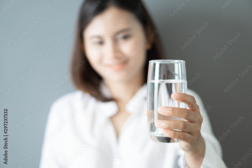 Close up woman hand holding glass of pure water with smile face background, Selective focus Close up woman hand holding glass of pure water with smile face background, Selective focus