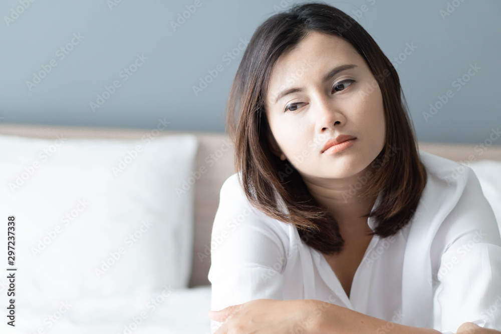 Closeup woman sitting on bed in the bedroom with thinking or depressed feeling, selective focus Closeup woman sitting on bed in the bedroom with thinking or depressed feeling, selective focus