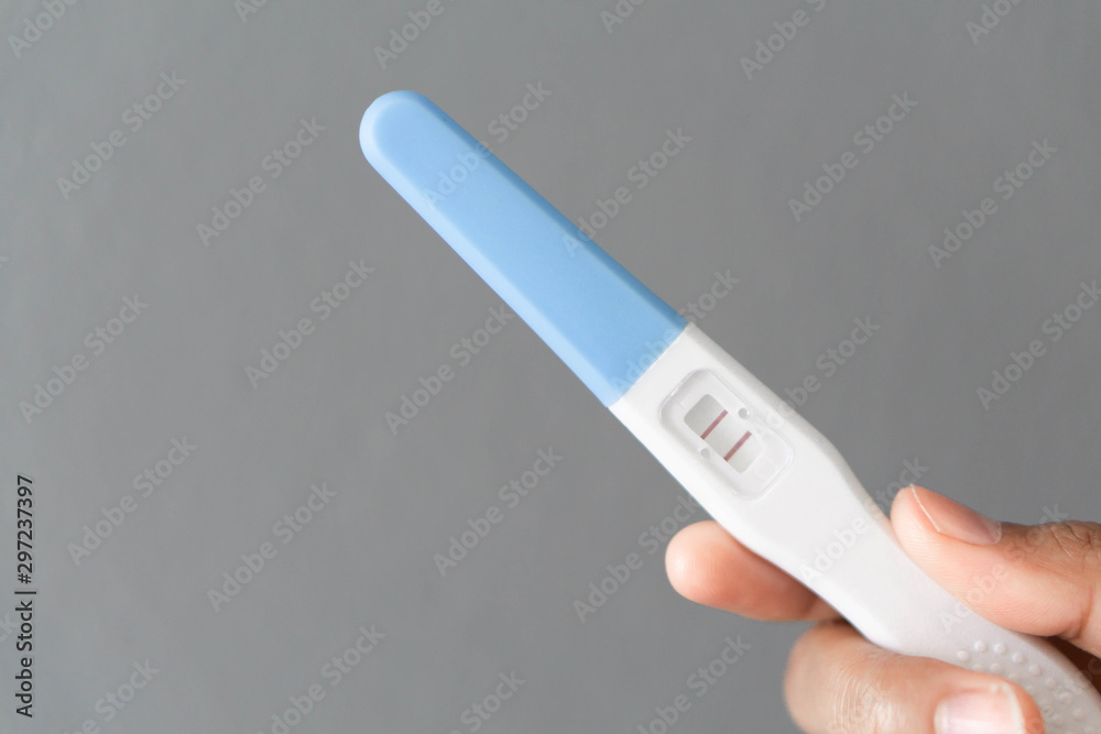 Closeup woman hand holding pregnancy test with happy moment, health care concept, selective focus Closeup woman hand holding pregnancy test with happy moment, health care concept, selective focus