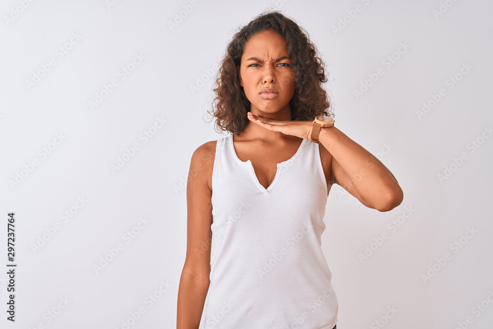 Young brazilian woman wearing casual t-shirt standing over isolated white background cutting throat with hand as knife, threaten aggression with furious violence