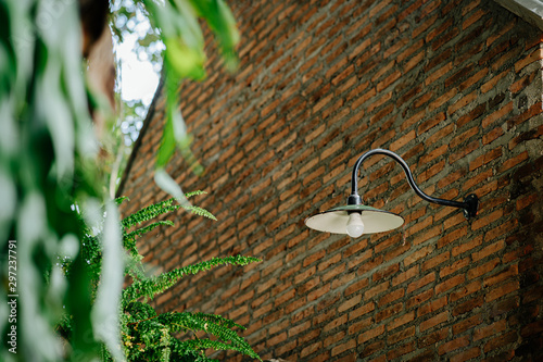 Lamp that is attached to a brick wall that has not been plastered.