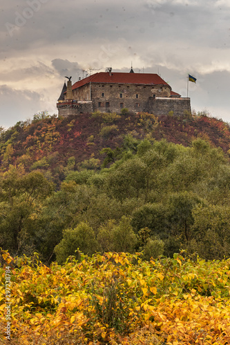 Palanok Castle or Mukachevo Castle. Ukraine. Beautiful landscape with a medieval Mukachevo castle on a mountain among colorful fall foliage on a cloudy day. photo