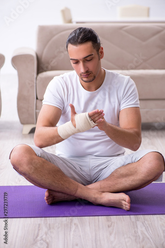 Hand injured man doing exercises at home