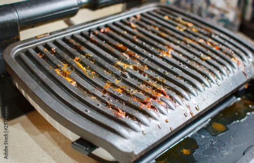 Dirty electric grill. Fat spots on a frying pan. Drops of fat.