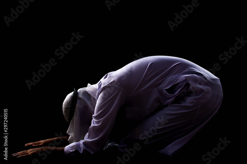 A muslim man is praying with dark background