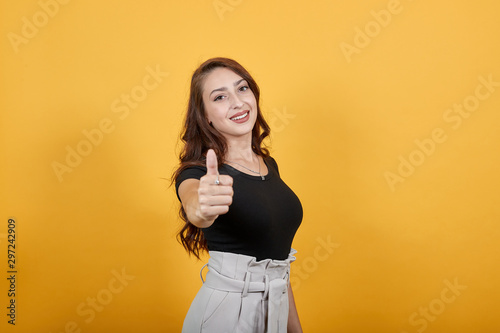 Happy girl giving a thumbs up which means she is very satisfied for whatever is presented to her. She is giving very positive response which is very helpful for any service and product.