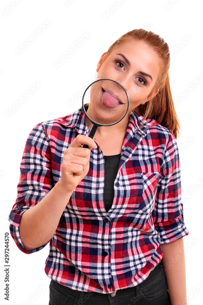 Young woman sticking her tongue out under magnifying glass Young woman sticking her tongue out under magnifying glass