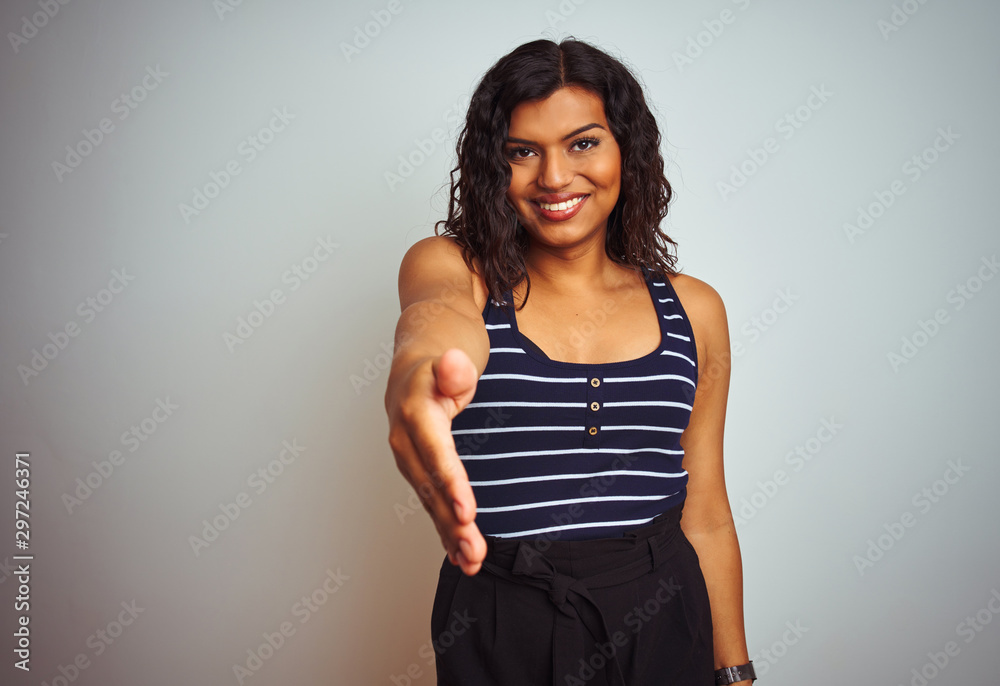 Transsexual transgender woman wearing striped t-shirt over isolated white background smiling friendly offering handshake as greeting and welcoming. Successful business. Transsexual transgender woman wearing striped t-shirt over isolated white background smiling friendly offering handshake as greeting and welcoming. Successful business.