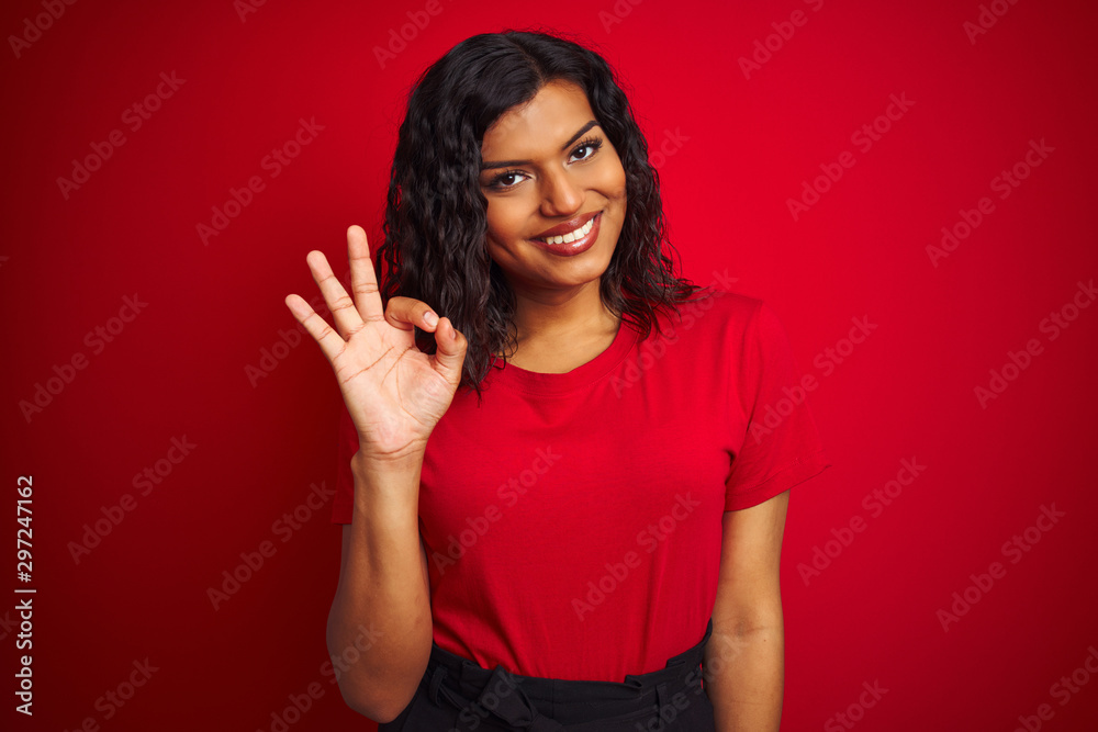 Beautiful transsexual transgender woman wearing t-shirt over isolated red background smiling positive doing ok sign with hand and fingers. Successful expression. Beautiful transsexual transgender woman wearing t-shirt over isolated red background smiling positive doing ok sign with hand and fingers. Successful expression.