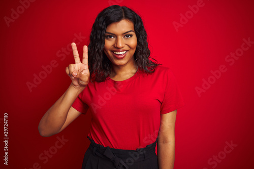 Beautiful transsexual transgender woman wearing t-shirt over isolated red background showing and pointing up with fingers number two while smiling confident and happy. © Krakenimages.com