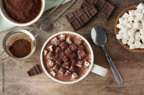 Composition with delicious hot cocoa drink and marshmallows on wooden background, flat lay
