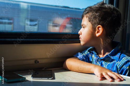 6 years old boy travelling in the train. looks out the window