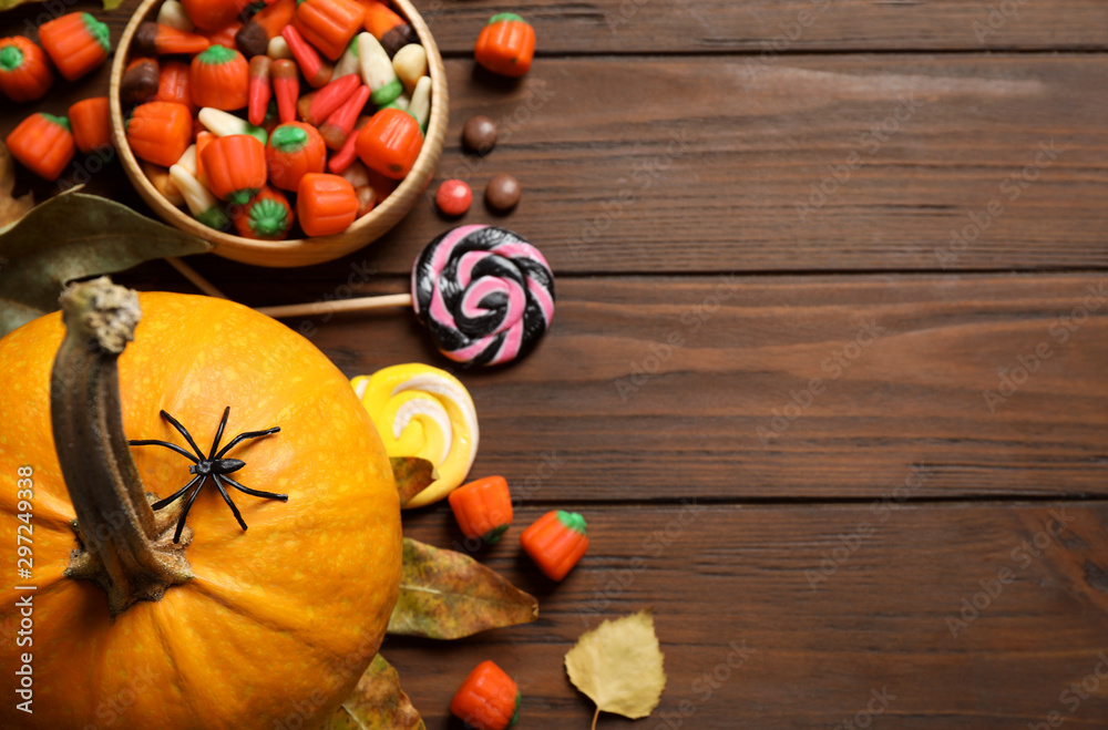 Flat lay composition with pumpkin head Jack lantern and Halloween treats on wooden background. Space for text Flat lay composition with pumpkin head Jack lantern and Halloween treats on wooden background. Space for text
