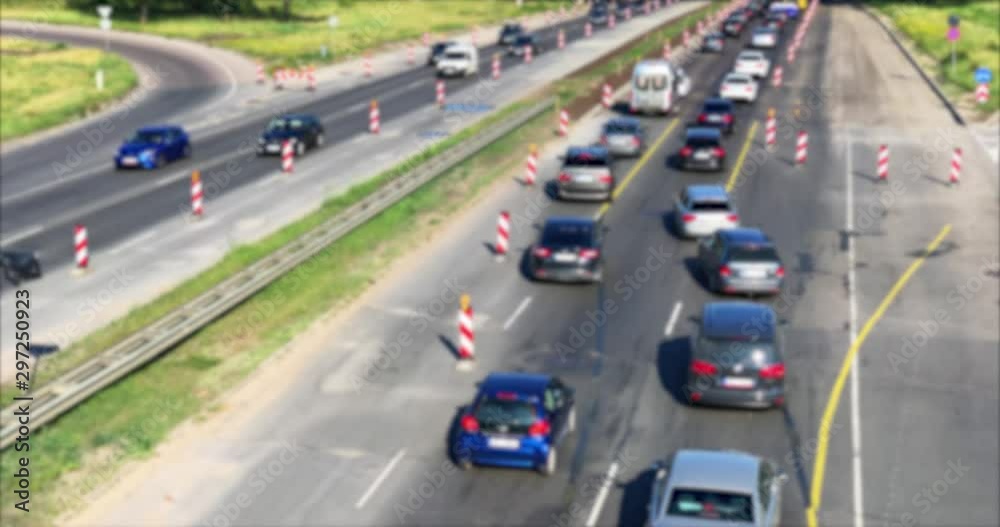 Roadwork cones managing the traffic flow. Traffic jam out of focus. Roadwork cones managing the traffic flow. Traffic jam out of focus.