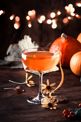 Satans whiskers, halloween cocktail with gin, vermouth, orange juice and liquor, vintage dark wooden background with festive decor