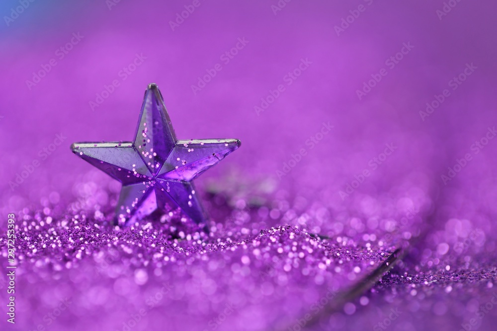 Christmas background.Violet star close-up on a lilac glitter background on a blurry purple background. - obrazy, fototapety, plakaty 