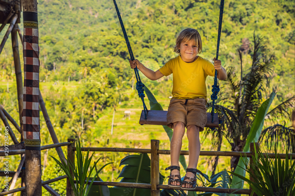 Young boy swinging in the jungle rainforest of Bali island, Indonesia.  Swing in the tropics. Swings -