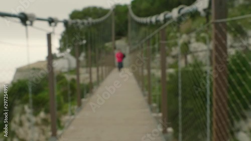 Out of focus of person crossing Windsor Suspension Bridge in Gibraltar.