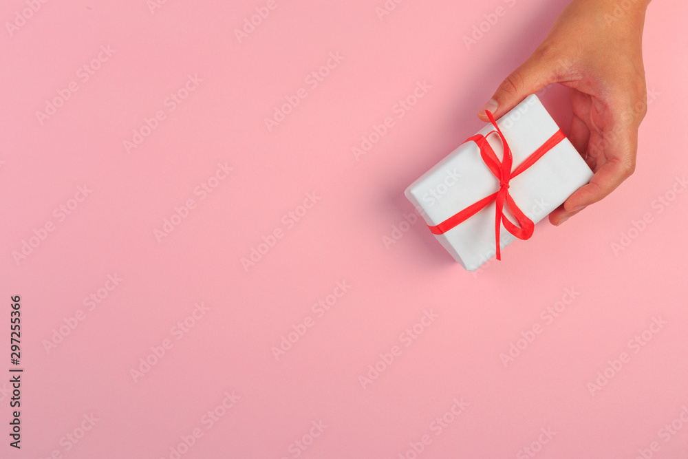 Obraz premium gift in female hands on a colored background top view. - Image