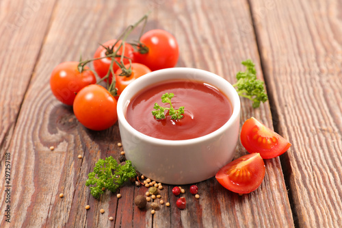 tomato sauce with pepper and parsley on wood background