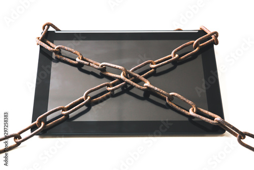 Rusty chains around the tablet. Addicted to modern technologies.