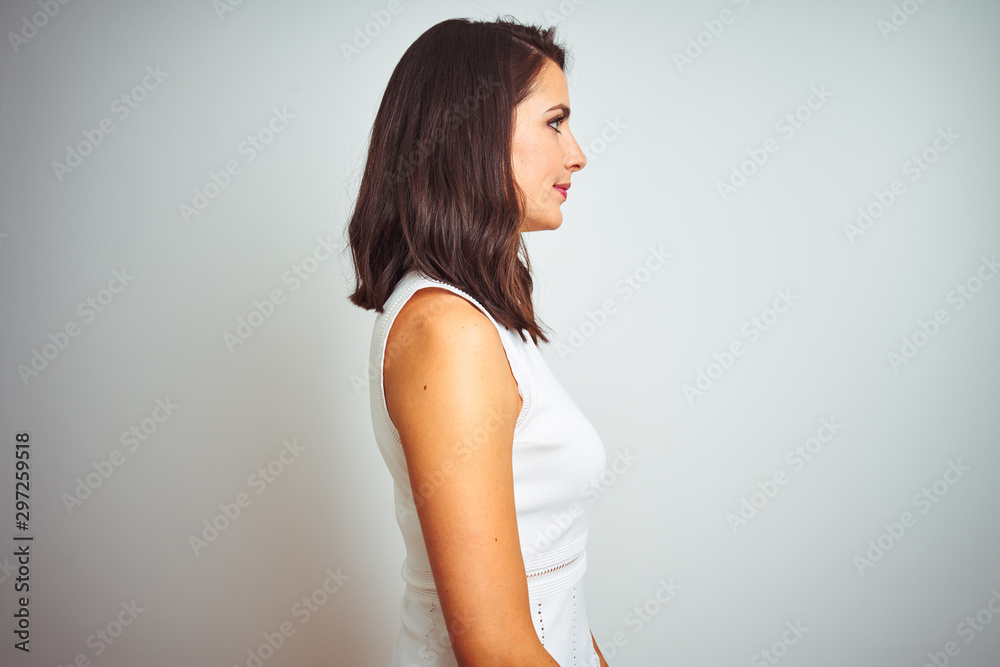Young beautiful woman wearing dress standing over white isolated background looking to side, relax profile pose with natural face and confident smile. Young beautiful woman wearing dress standing over white isolated background looking to side, relax profile pose with natural face and confident smile.