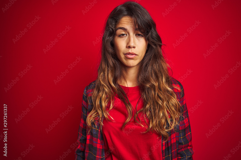 Young beautiful woman wearing casual jacket standing over red isolated background looking surprised and shocked doing ok approval symbol with fingers. Crazy expression Young beautiful woman wearing casual jacket standing over red isolated background looking surprised and shocked doing ok approval symbol with fingers. Crazy expression