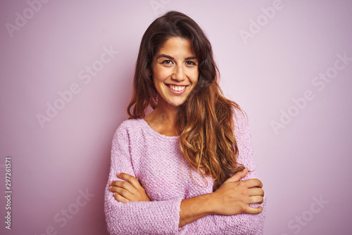 Young beautiful woman wearing sweater standing over pink isolated background happy face smiling with crossed arms looking at the camera. Positive person. © Krakenimages.com